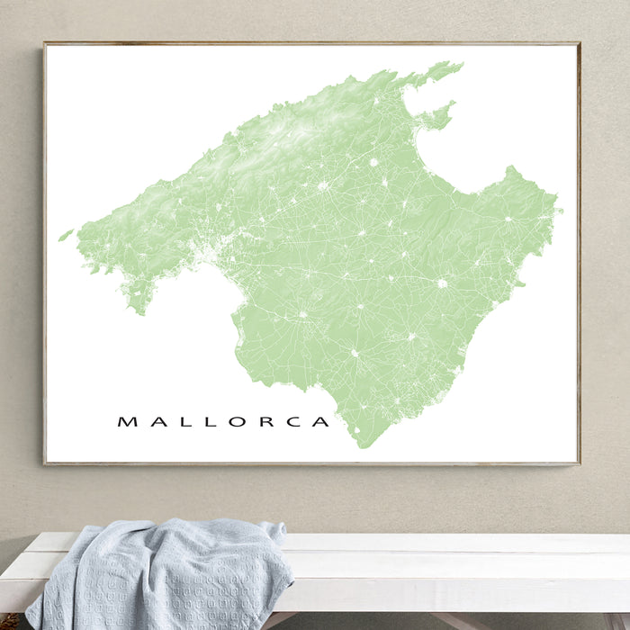 Framed map of Mallorca on a wall above a white surface with a towel.
