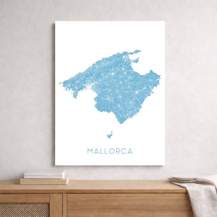 Map of Mallorca framed on a wall above a wooden shelf.