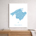 Map of Mallorca framed on a wall above a wooden shelf.