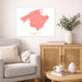Living room with a gray sofa, wooden cabinet, and a framed map of Mallorca on the wall.