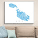 Framed map of Malta on a wall above a beige sofa with light blue cushions.