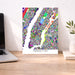Colorful Manhattan map poster on a desk with a laptop and plant.