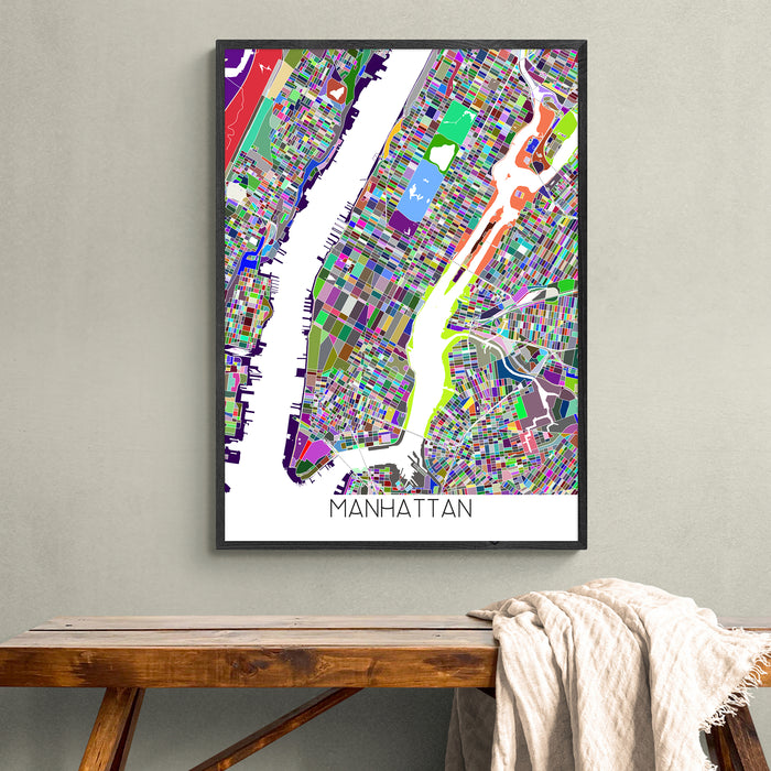 Framed colorful map of Manhattan on a wall above a wooden bench.