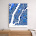Map of Manhattan in blue and white on a wall above a wooden shelf.