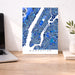 Manhattan map poster on a desk with a laptop and plant