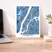 Manhattan map poster on a desk with a laptop and plant