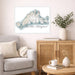 Living room with a map of Martha's Vineyard on the wall, a couch, and a side table with a vase and books.