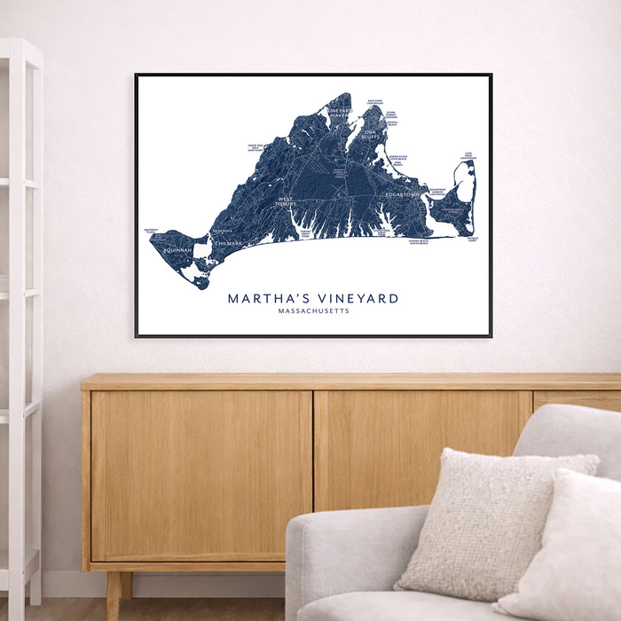 Framed map of Martha's Vineyard on a wall above a wooden cabinet and sofa.