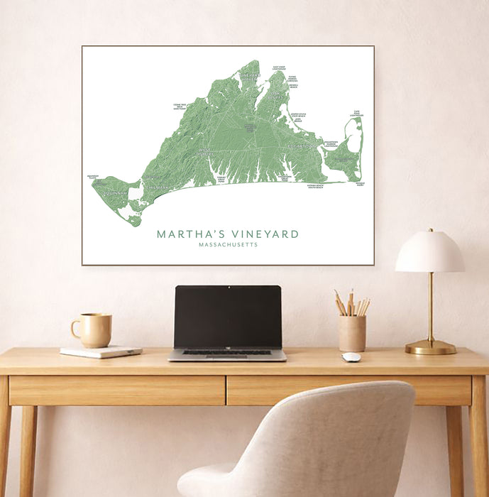 Framed map of Martha's Vineyard above a desk with a laptop and lamp.