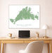 Framed map of Martha's Vineyard above a desk with a laptop and lamp.