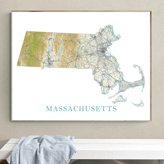 Framed map of Massachusetts on a wall above a white surface with a gray towel.