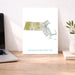 Map of Massachusetts on a desk with a laptop and plant