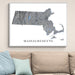 Map of Massachusetts on a wall above a beige sofa with light blue pillows.