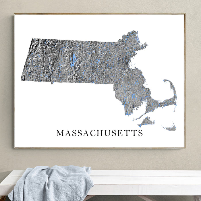Framed map of Massachusetts on a wall above a white surface with a gray towel.