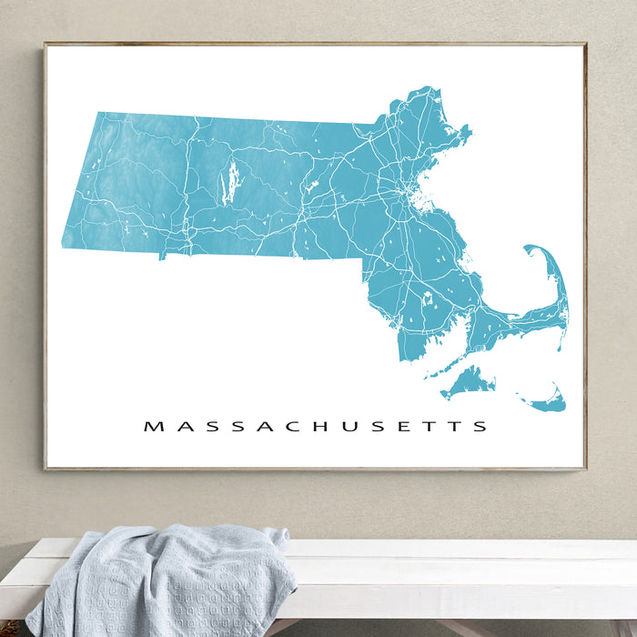 Map of Massachusetts framed on a wall above a white bench.