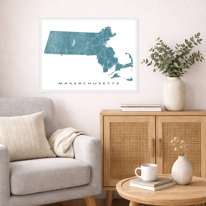 Framed map of Massachusetts on a wall above a sofa in a living room.