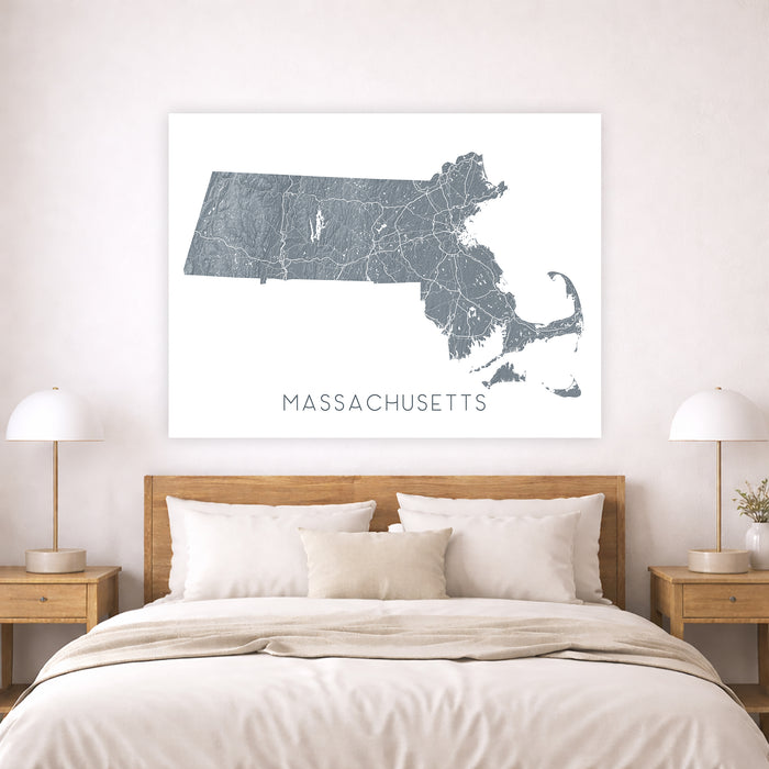 Map of Massachusetts on a wall above a bed in a bedroom setting