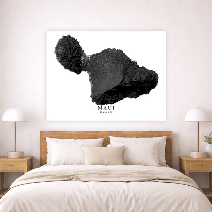 Framed map of Maui, Hawaii above a bed in a bedroom setting.