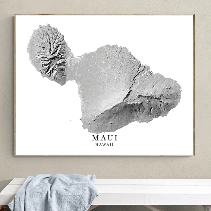 Framed map of Maui, Hawaii on a wall above a white bench.