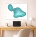 Framed map of Maui on a wall above a desk with a laptop and lamp.