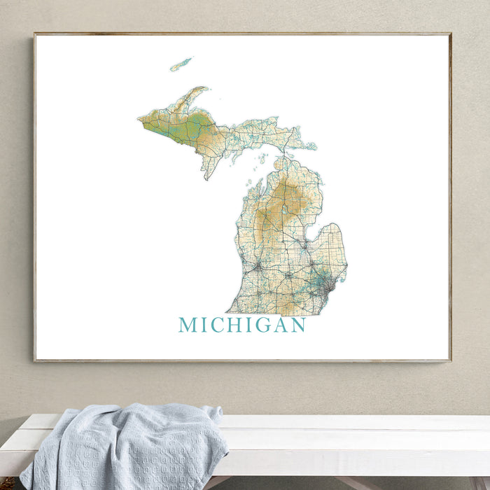 Framed map of Michigan on a wall above a white surface with a light gray towel.