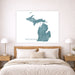 Map of Michigan on a wall above a bed in a bedroom setting