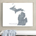 Framed map of Michigan on a wall above a white bench.