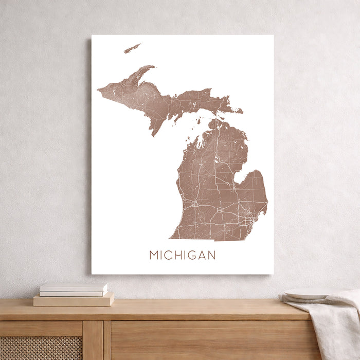 Map of Michigan on a white wall above a wooden shelf.