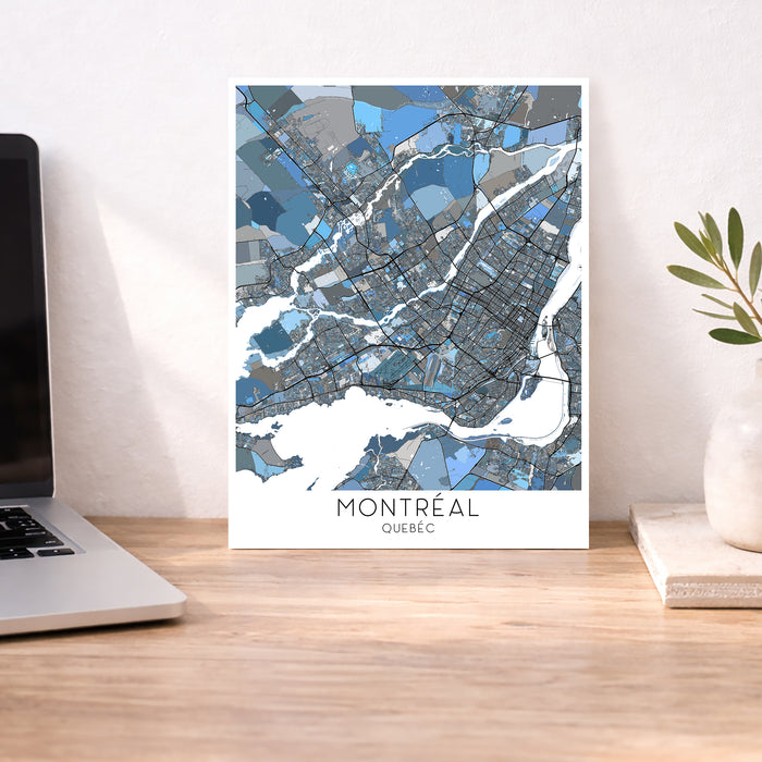 Map of Montreal on a wall above a desk with a laptop and plant.