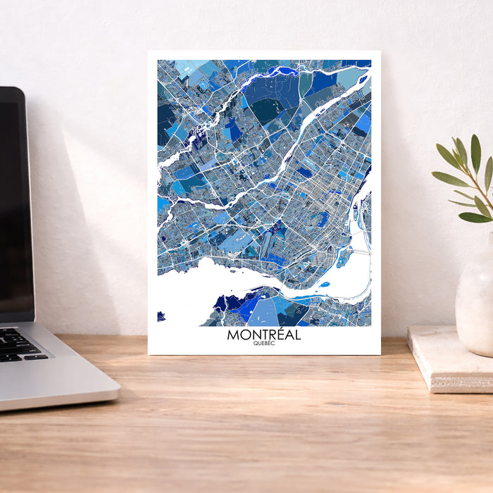 Map of Montreal on a wall above a desk with a laptop and plant.
