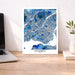 Map of Montreal on a wall above a desk with a laptop and plant.