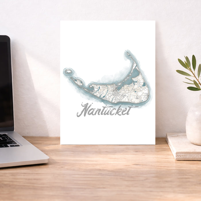 Map of Nantucket on a white background next to a laptop on a wooden desk.