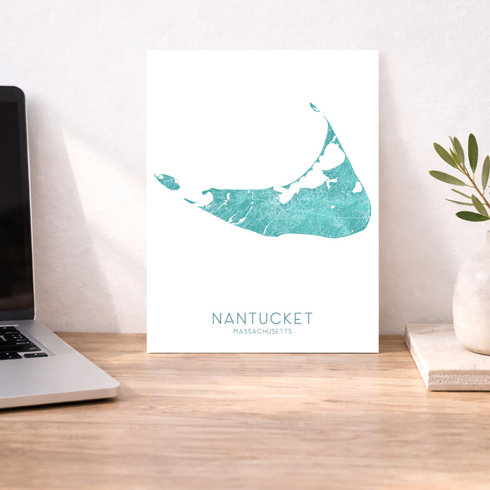 Nantucket Massachusetts map print on a desk with a laptop and plant.