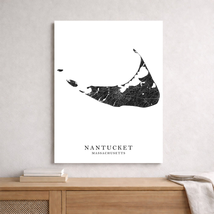 Framed black and white map of Nantucket, Massachusetts on a wall above a wooden shelf.