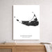 Framed black and white map of Nantucket, Massachusetts on a wall above a wooden shelf.