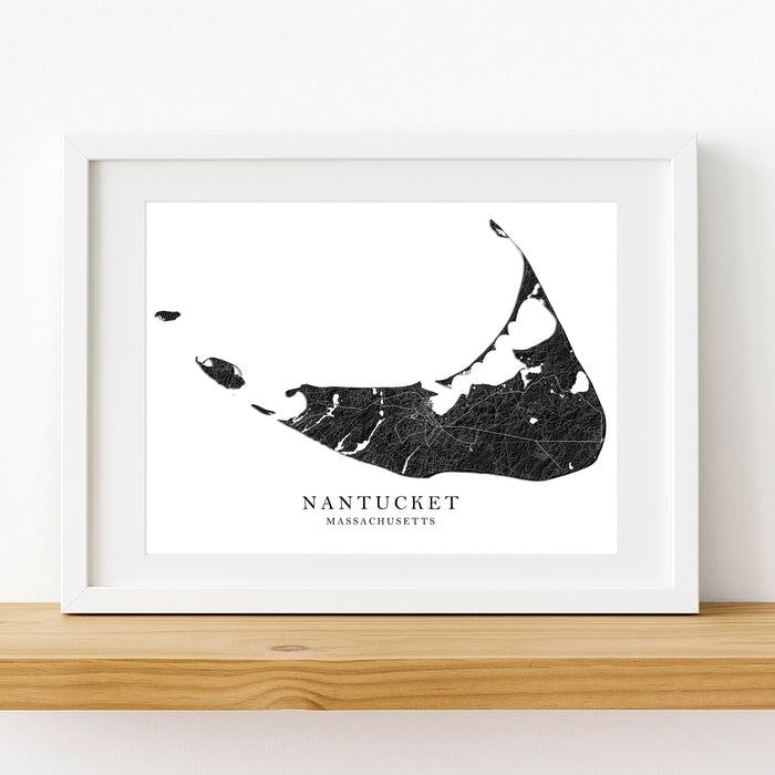 Framed black and white map of Nantucket, Massachusetts on a wooden shelf.