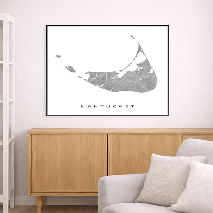Framed map of Nantucket on a wall above a wooden cabinet and sofa.