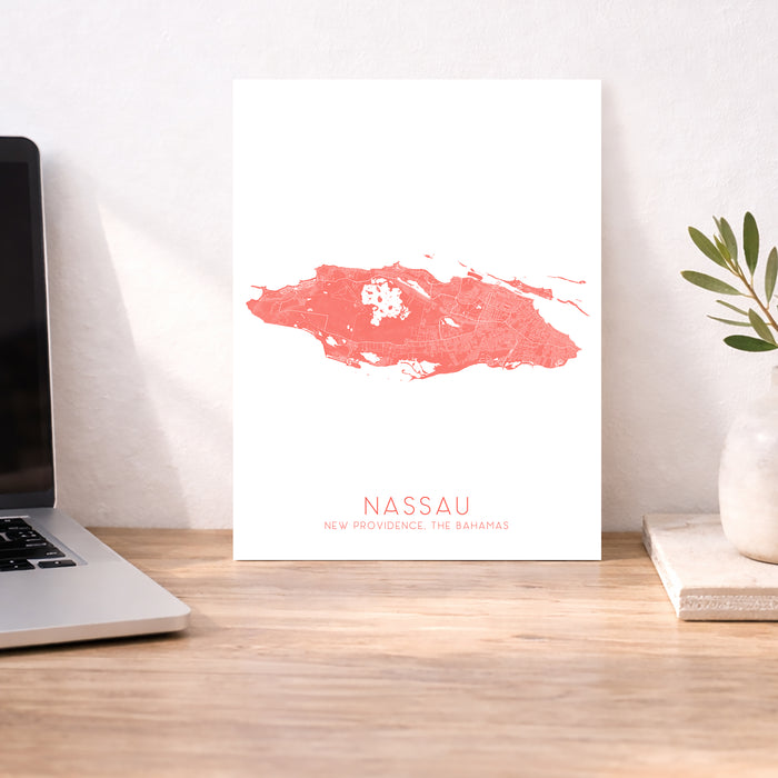 Map of Nassau on a white background next to a laptop on a wooden desk.