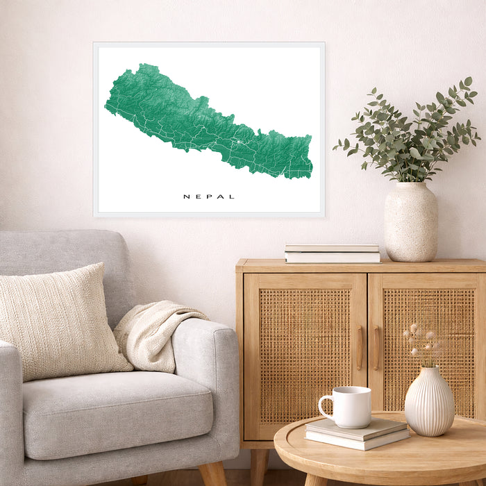 Living room with a map of Nepal on the wall, a couch, and a side table with a vase and books.