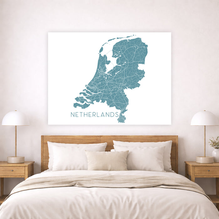 Map of the Netherlands on a wall above a bed in a bedroom.