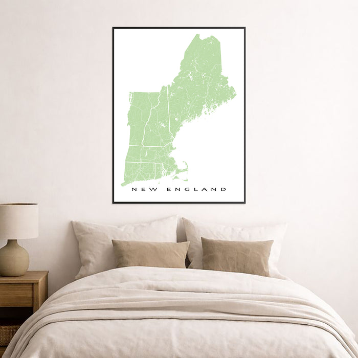 Framed map of New England on a wall above a bed.