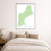 Framed map of New England on a wall above a bed.