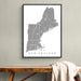 Framed map of New England on a wall above a wooden bench.