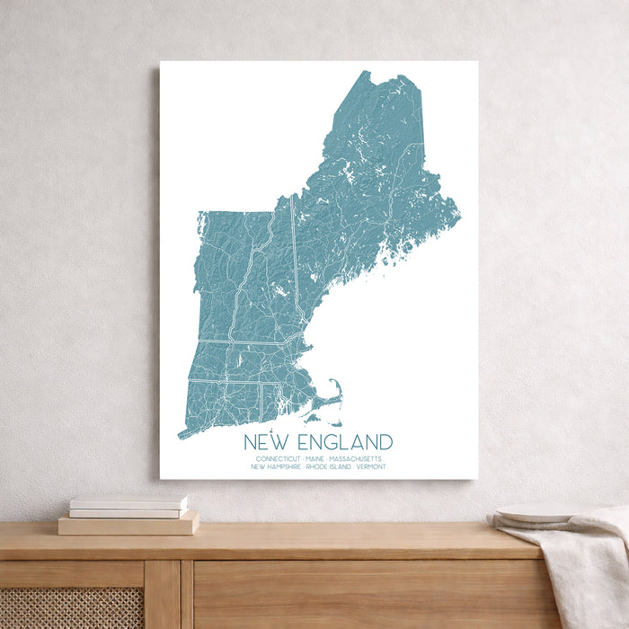 Map of New England on a white wall above a wooden shelf.