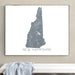 Framed map of New Hampshire on a wall above a white bench.