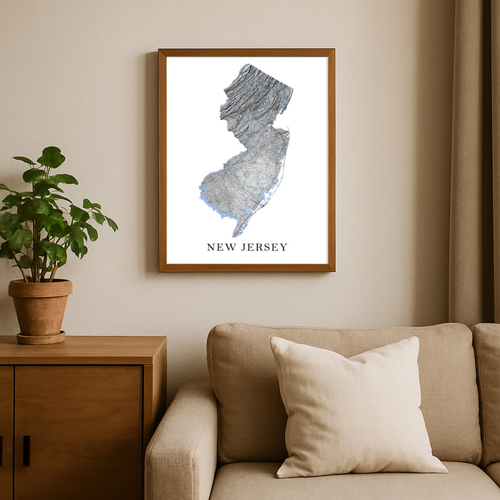 Framed map of New Jersey on a wall above a beige sofa with a plant beside it.