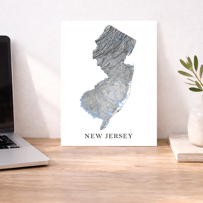 Map of New Jersey on a desk with a laptop and plant