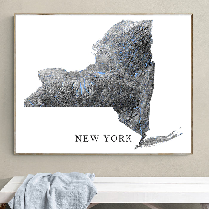 Framed map of New York on a wall above a white bench.