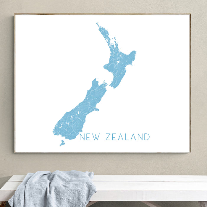Framed map of New Zealand on a wall above a bench.