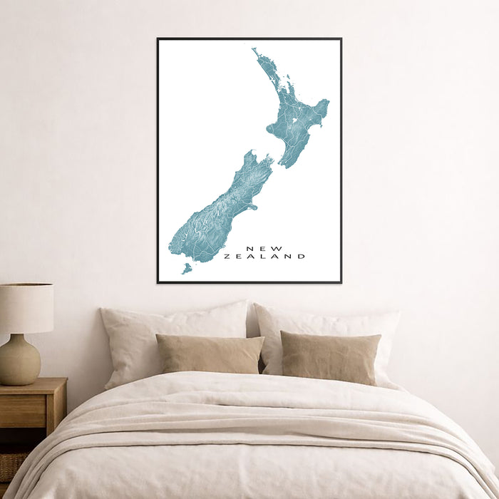 Framed map of New Zealand on a wall above a bed